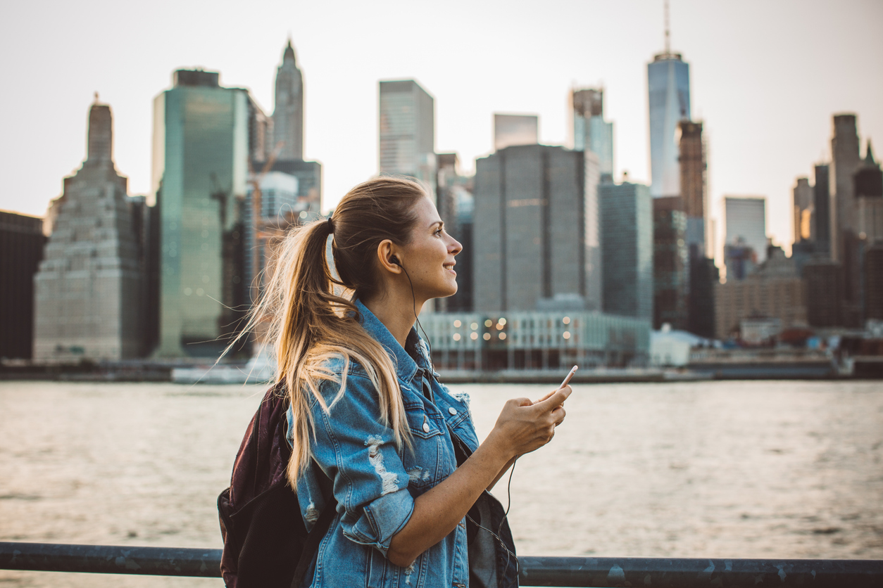 a woman standing on a railing with a city in the background