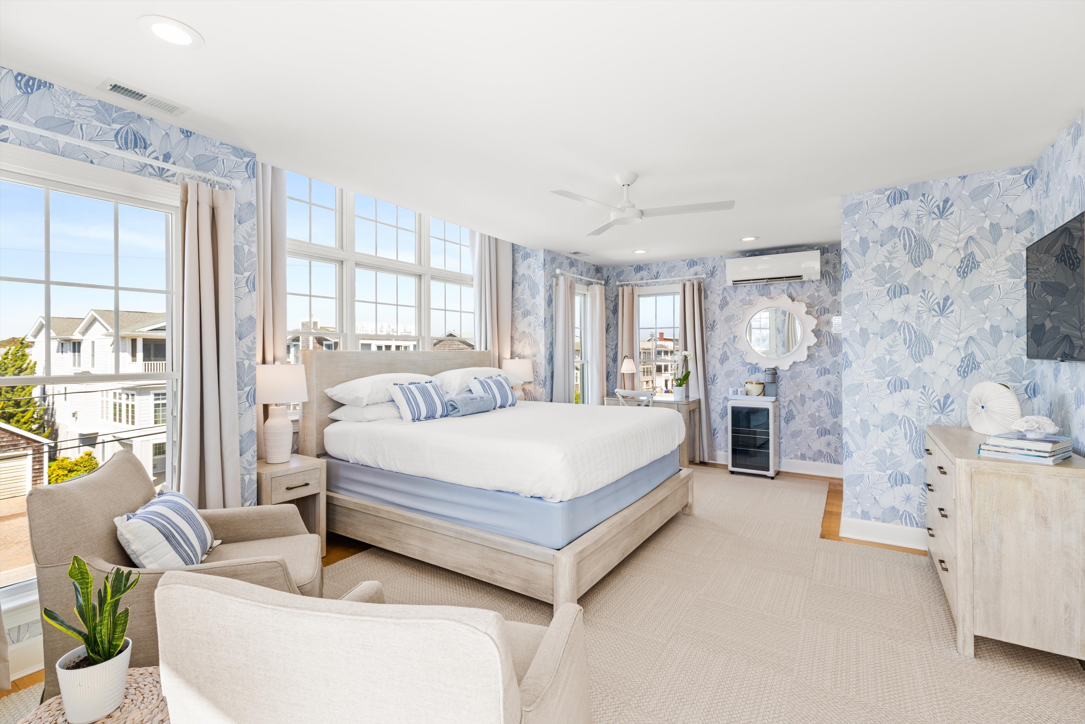 A wide view of a guest room with a large bed, comfortable seating, and a large window with a view.