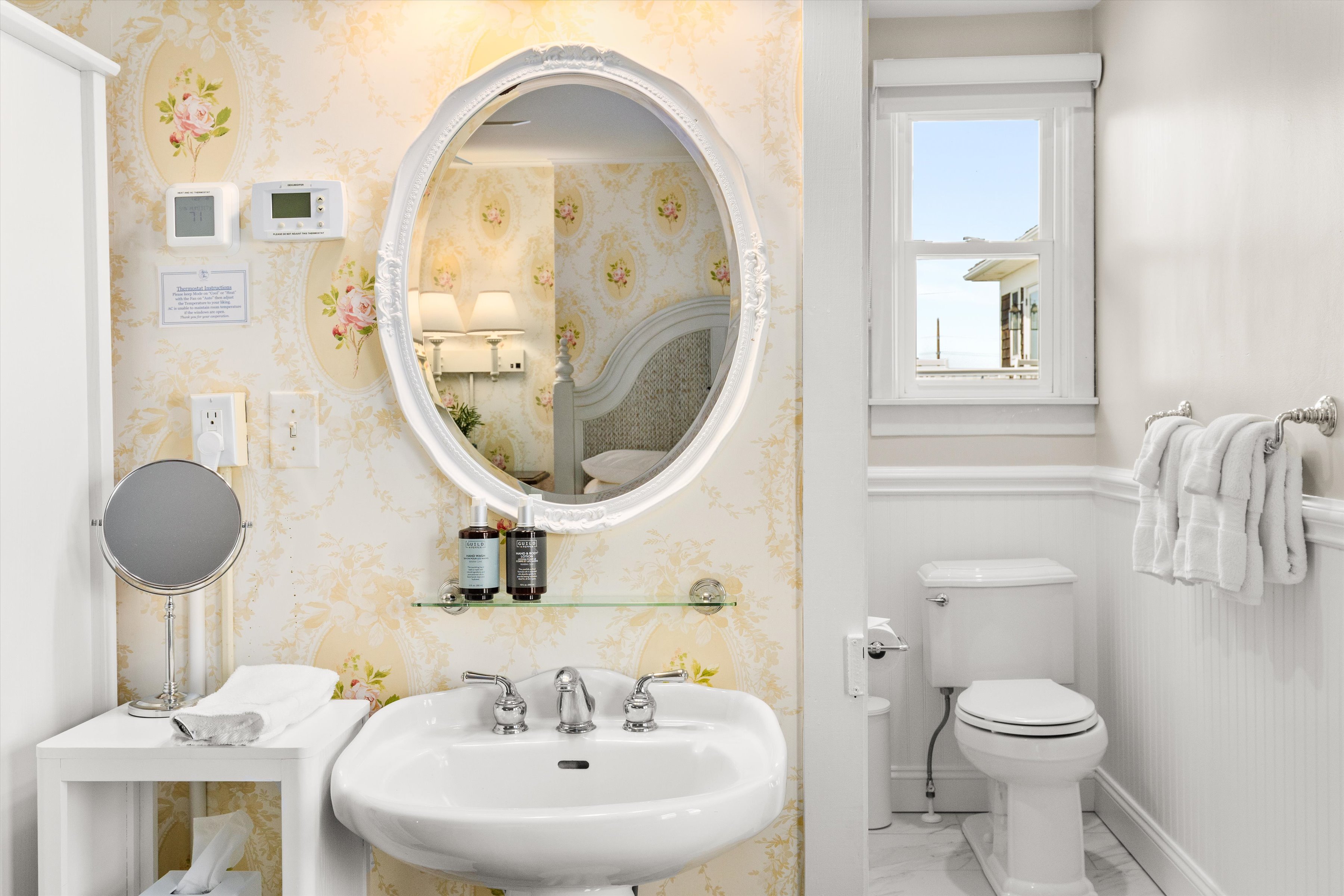 A clean and well-appointed bathroom with a white sink, toilet, and towels.