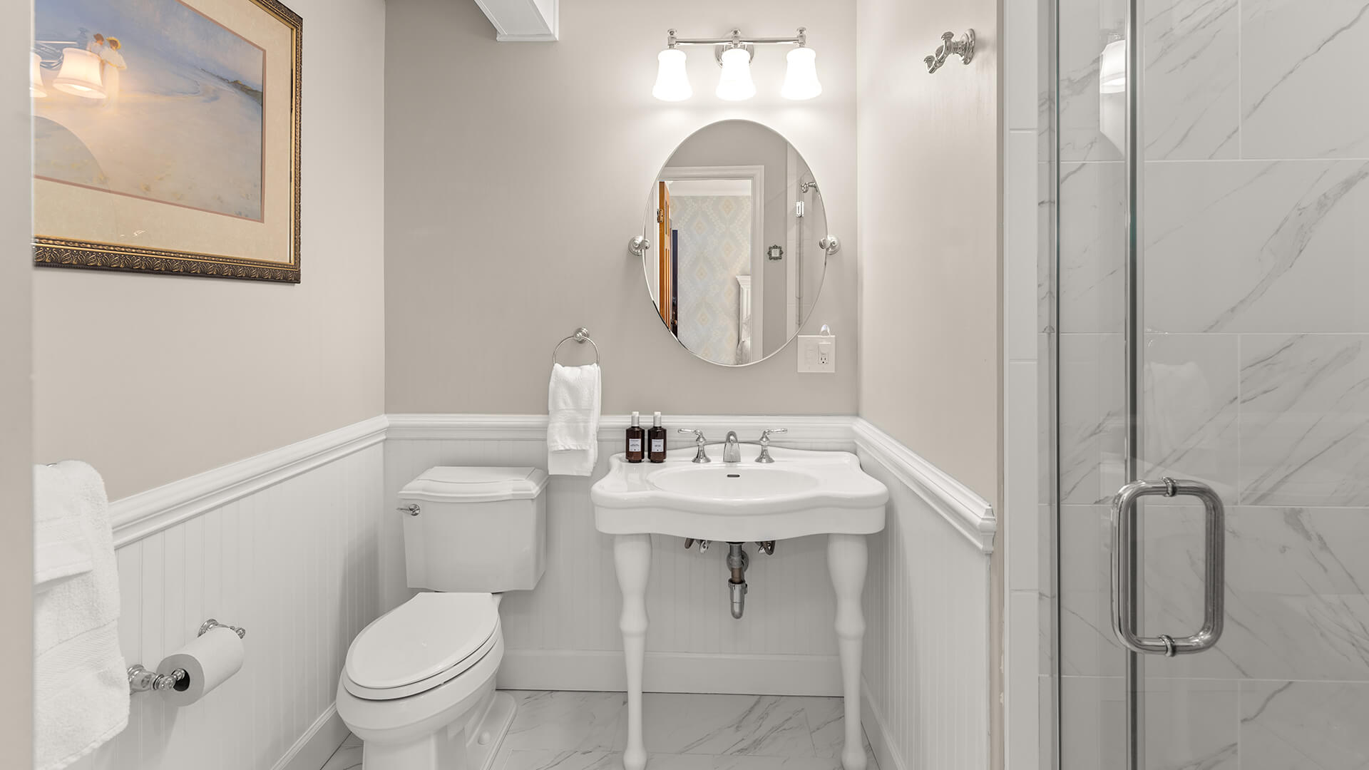 A clean and modern bathroom with a toilet, sink, and shower.