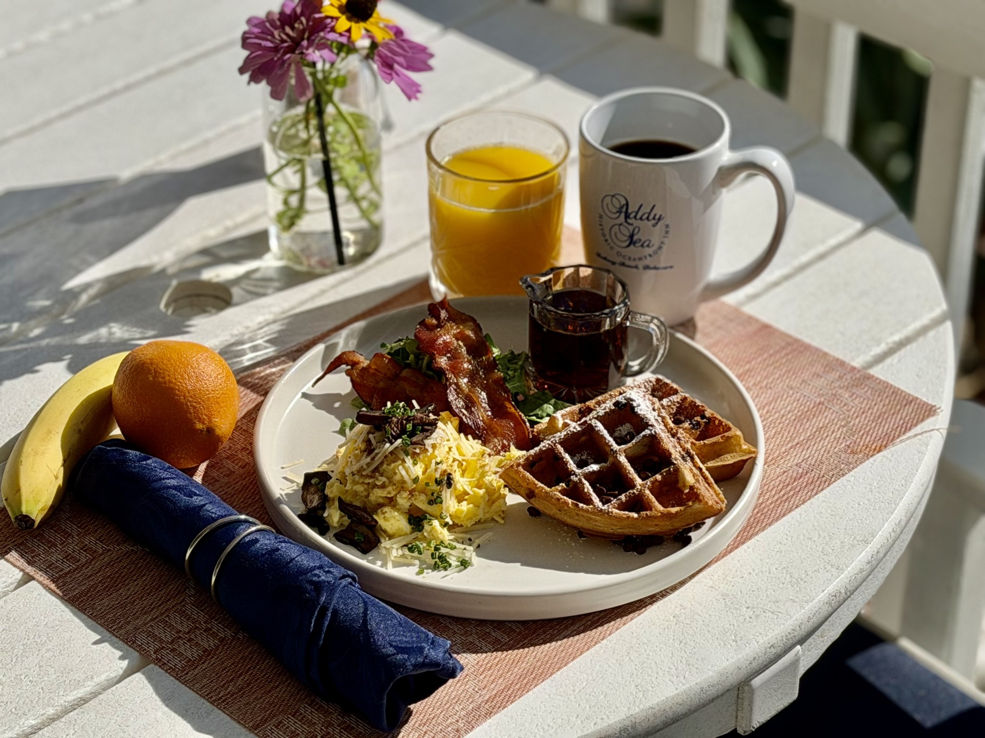 A breakfast plate with food and drinks on a table