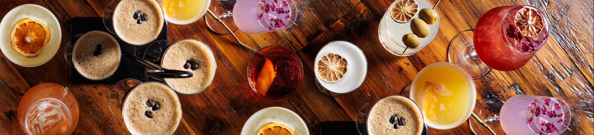 a group of glasses with drinks on a table