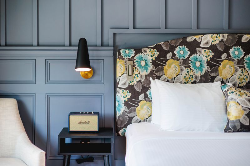 a bed with a floral headboard and a radio