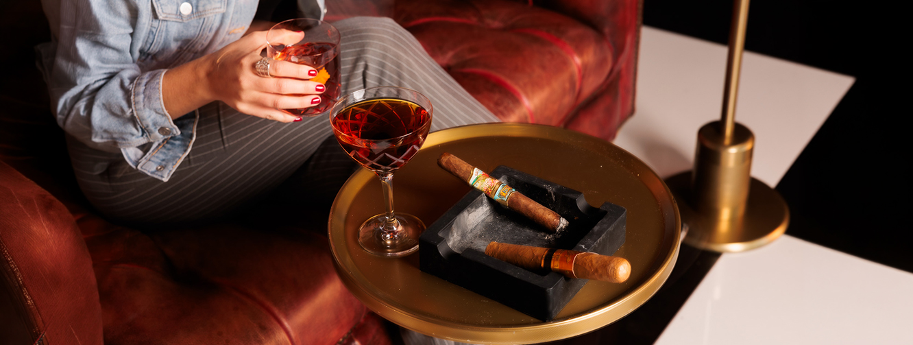 a cigars and a glass of wine on a table
