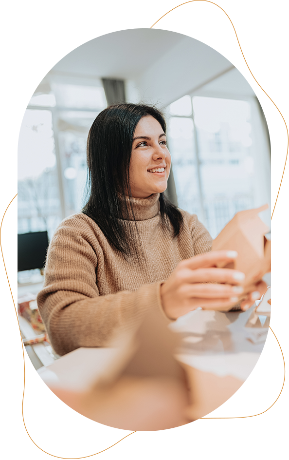 a woman smiling and holding a box