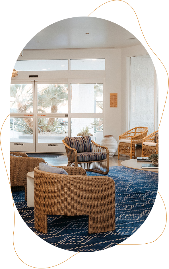 a room with wicker chairs and a blue rug