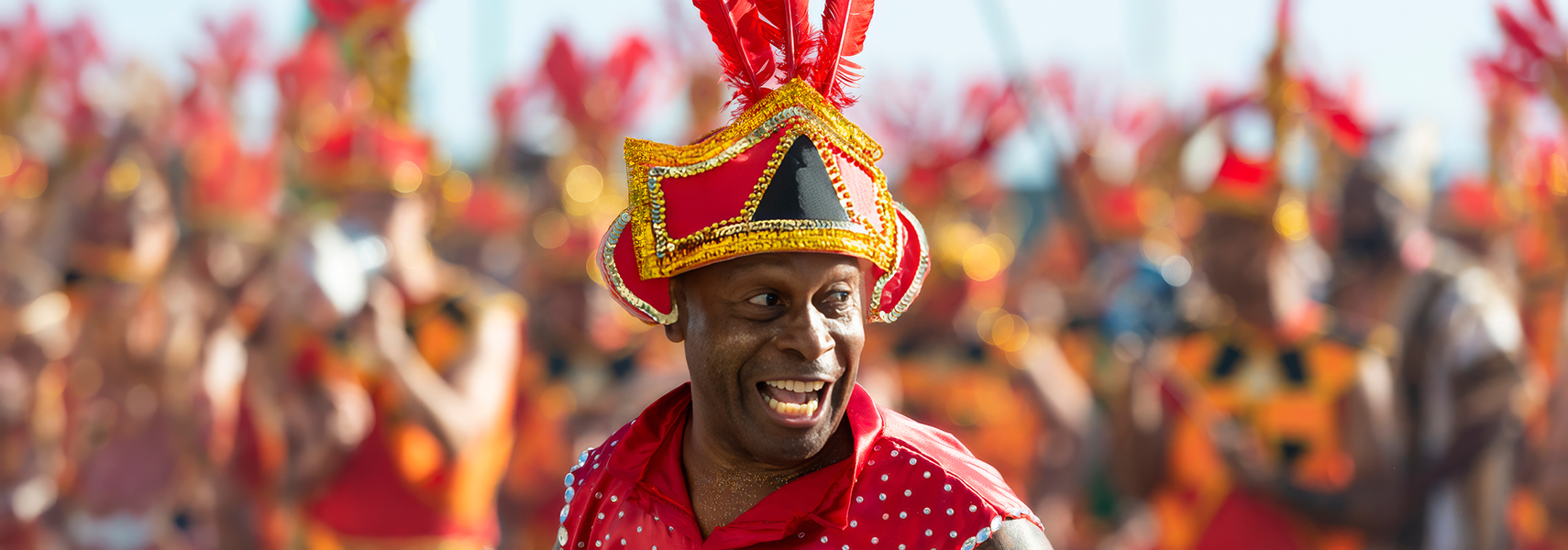 a man wearing a red and gold hat and red shirt