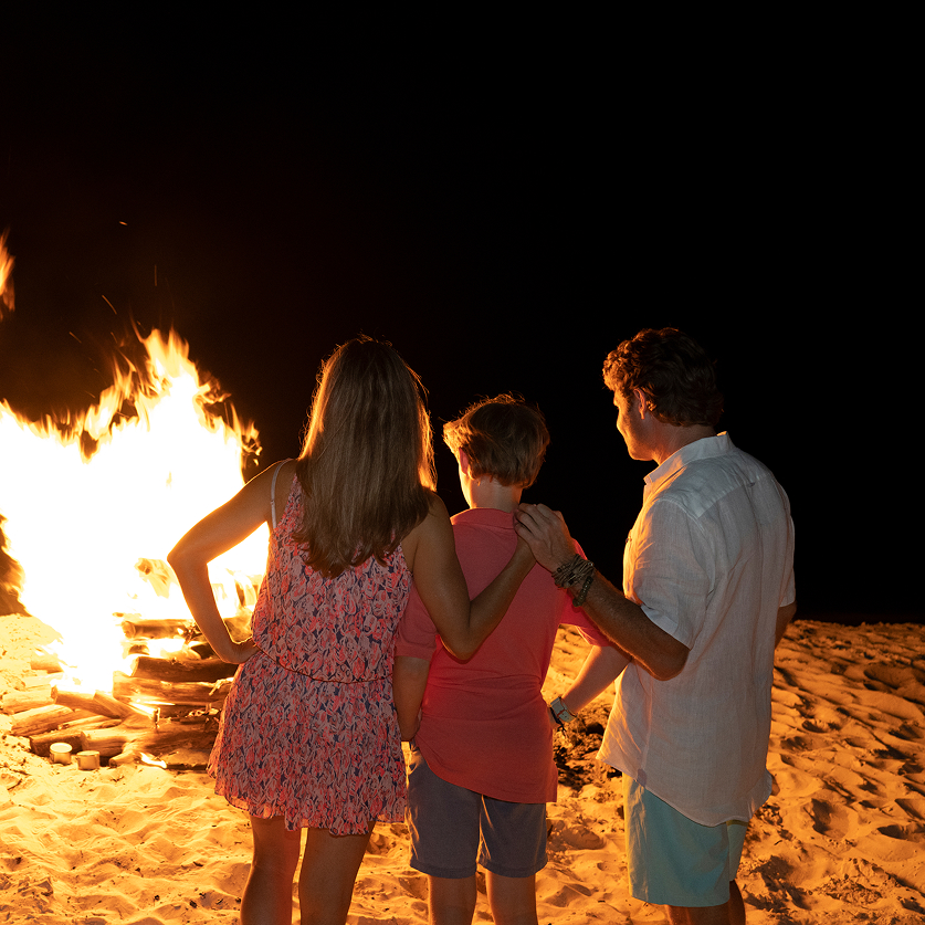 a group of people standing in front of a fire