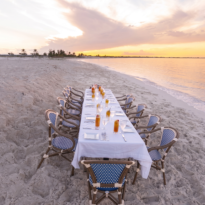a table set for a dinner on a beach