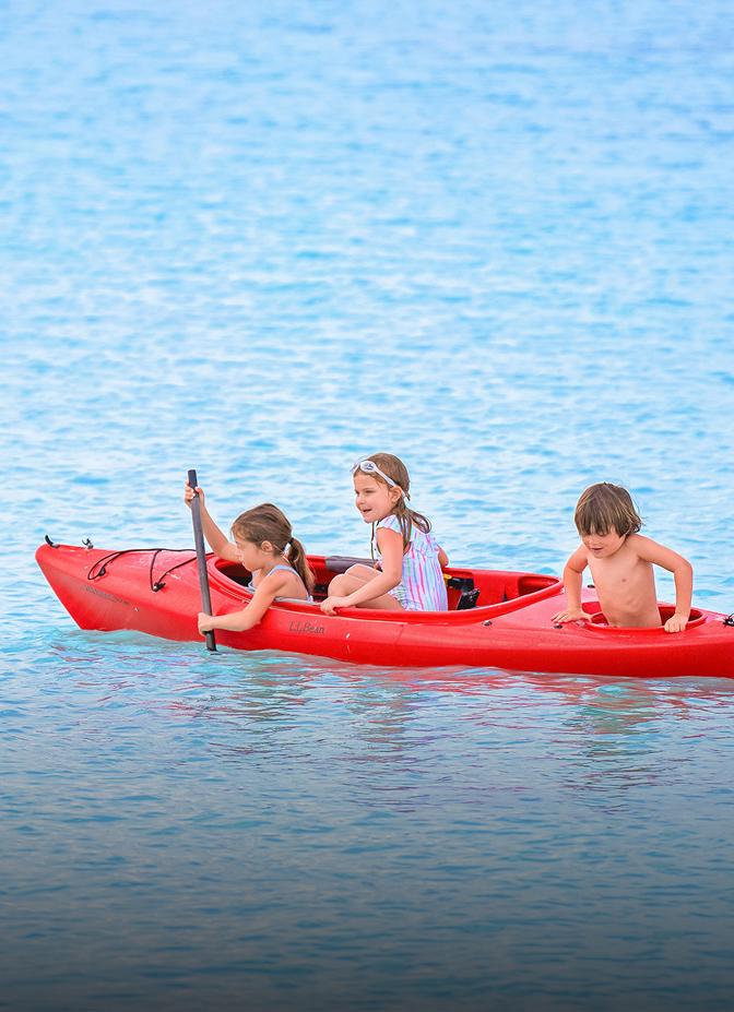 a group of kids in a red kayak