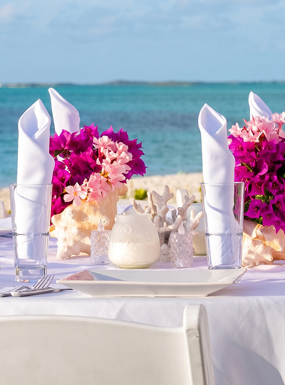 a table set with pink and purple flowers on it