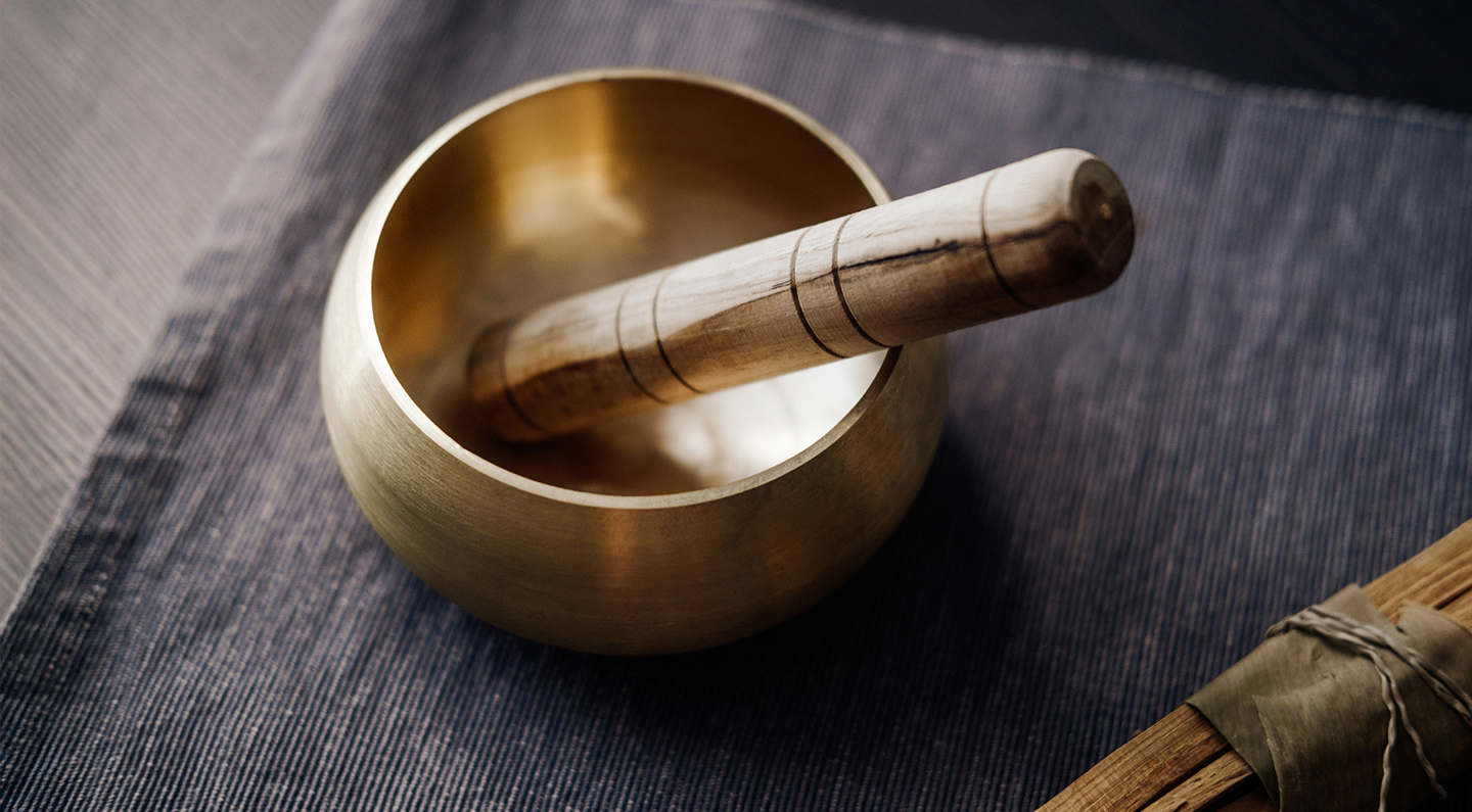 a brass bowl with a wooden handle