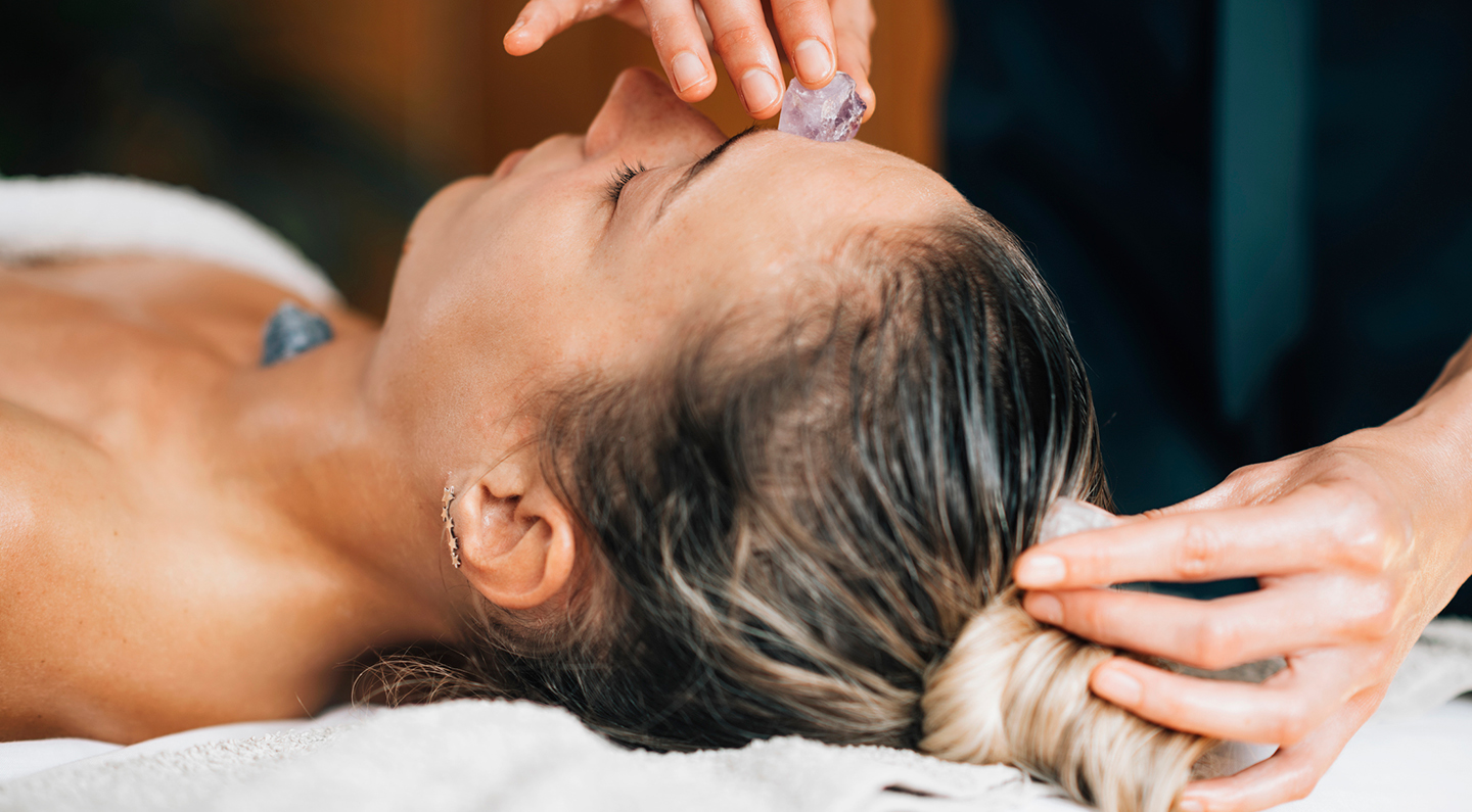 a woman receiving a crystal healing treatment