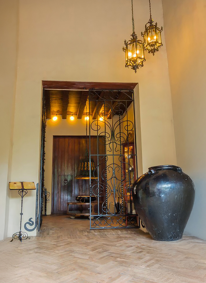 a large black vase next to a metal gate