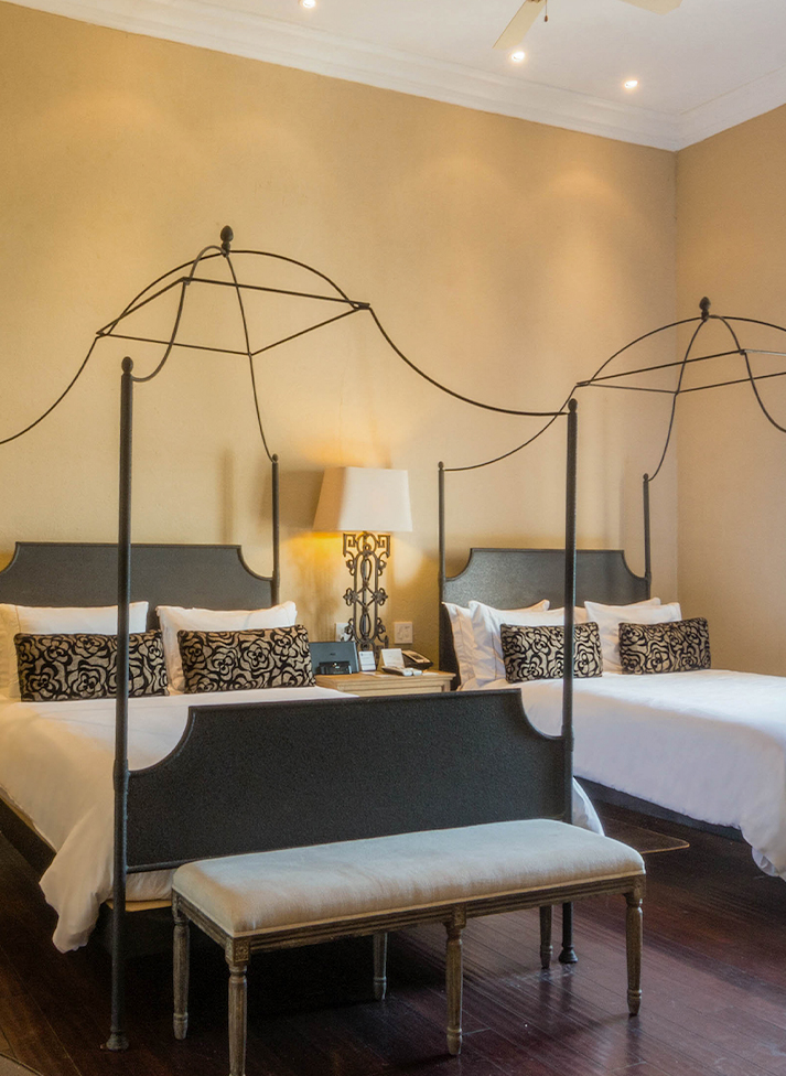 a room with two beds and a lamp