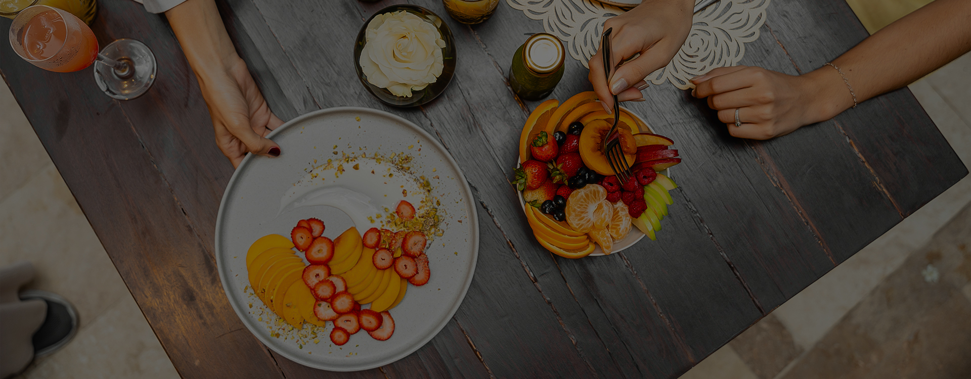 a plate of fruit and a hand holding a fork