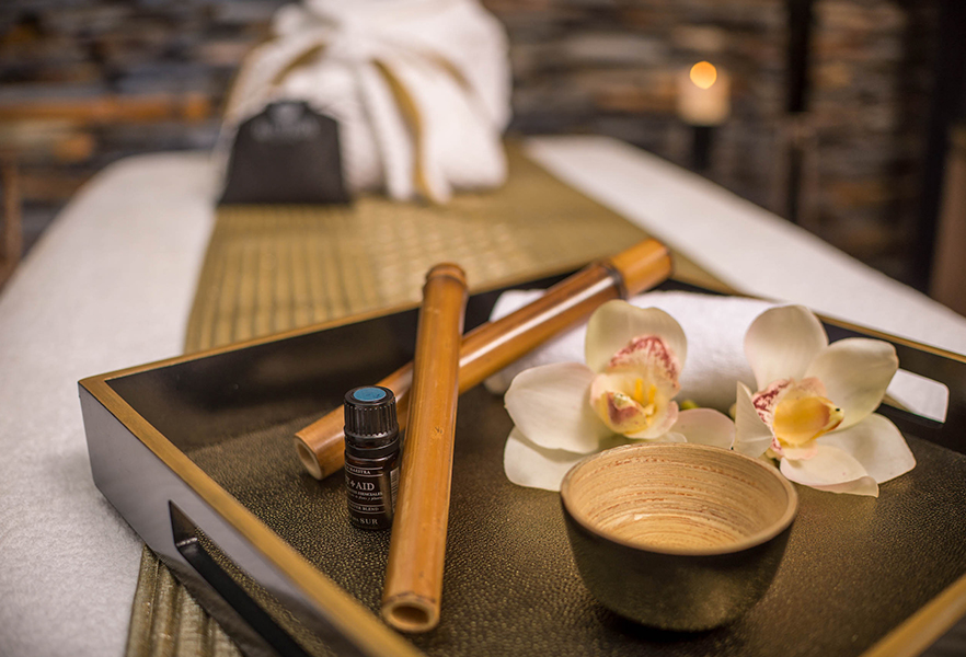 a tray with a bowl and a bowl and a bottle of essential oil