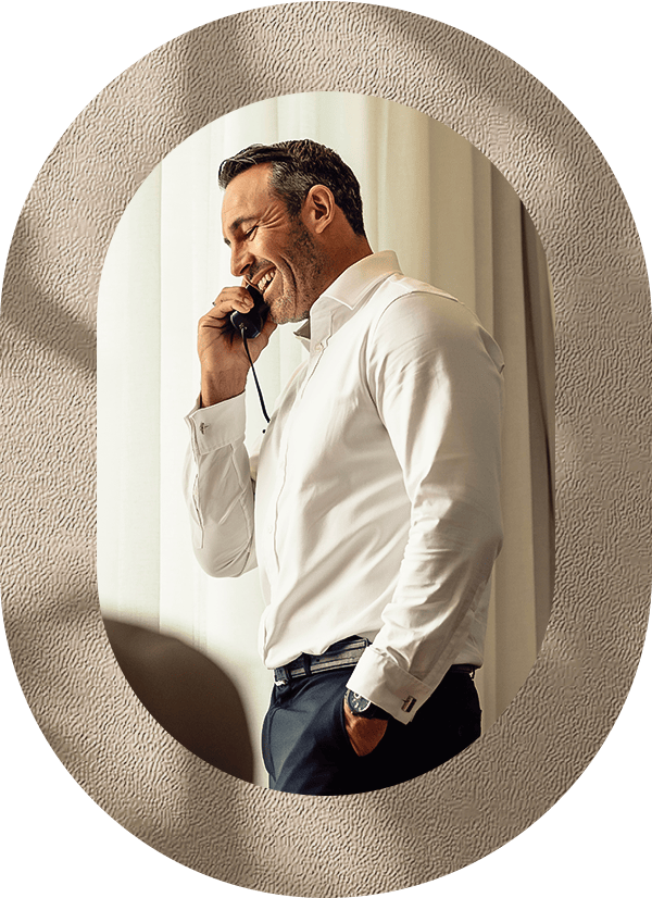 a man in a white shirt talking on a cell phone
