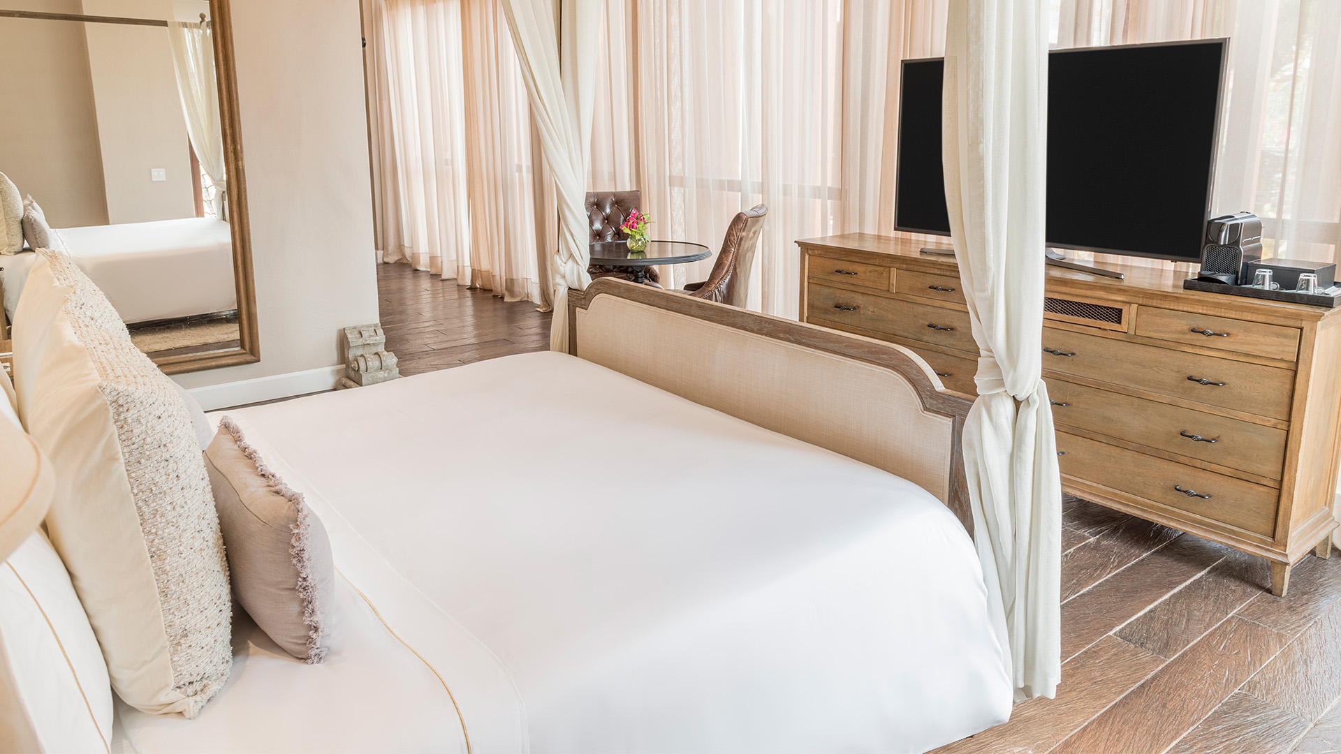 a bed with a white sheet and a television in a room