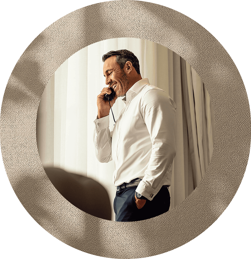 a man in a white shirt talking on a cell phone