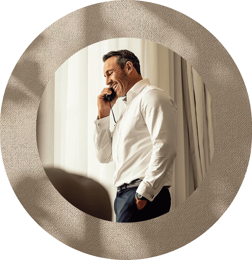 a man in a white shirt talking on a cell phone