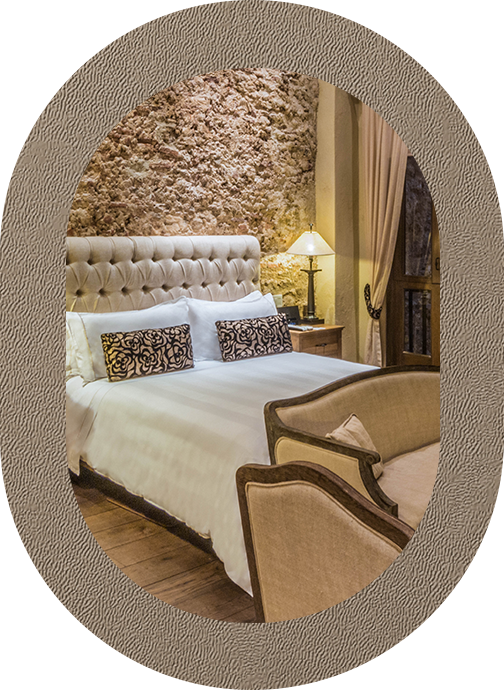 a bed with a lamp and a stone wall