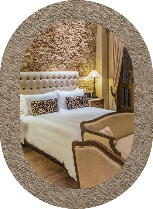 a bed with a lamp and a stone wall