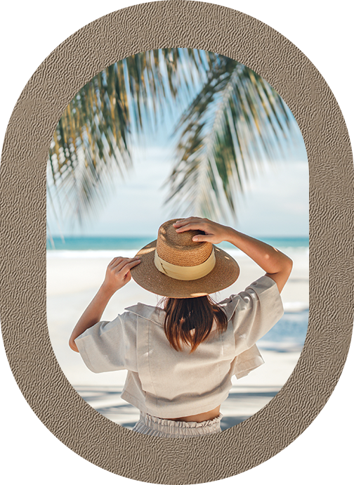 a woman wearing a hat looking out a window at the beach
