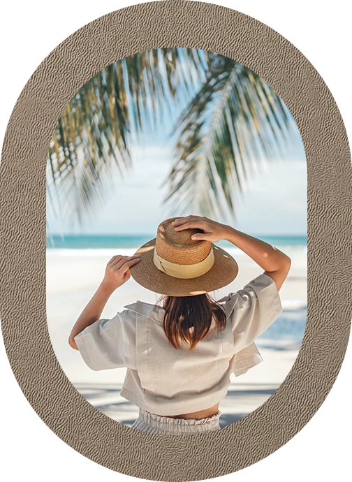 a woman wearing a hat looking out a window at the beach