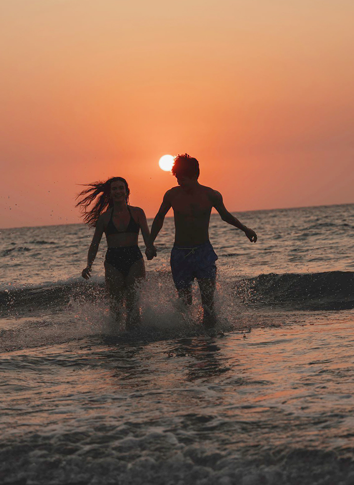 a man and woman running in water