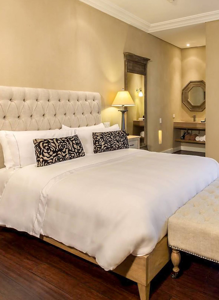 a bed with a white bedding and a lamp