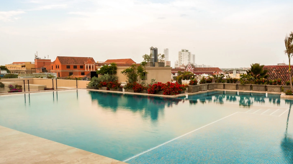 a pool with flowers and a building in the background