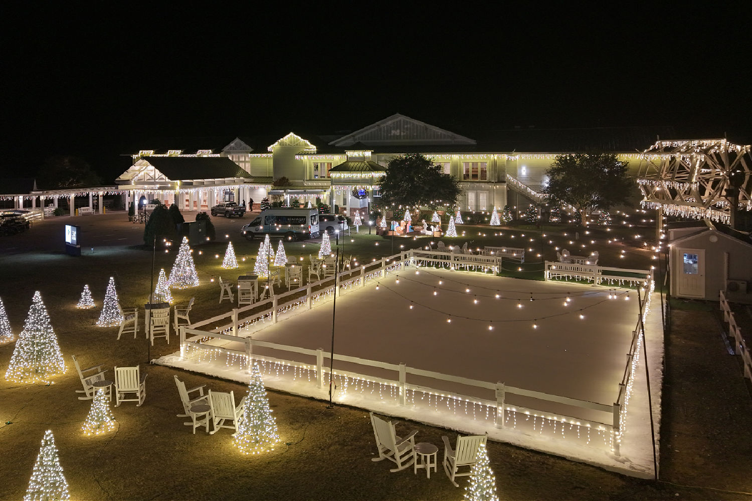 a large white building with christmas lights and trees