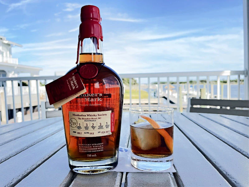 a bottle of alcohol and a glass of ice on a table