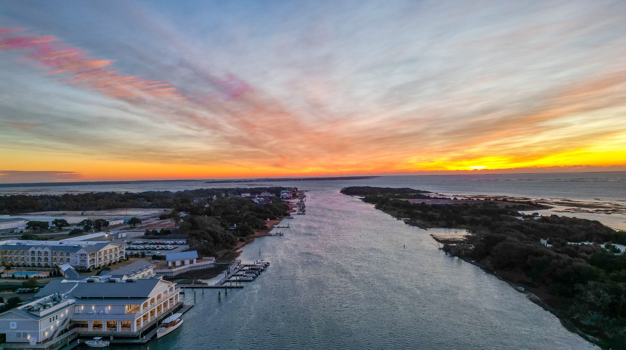 a body of water with buildings and a sunset
