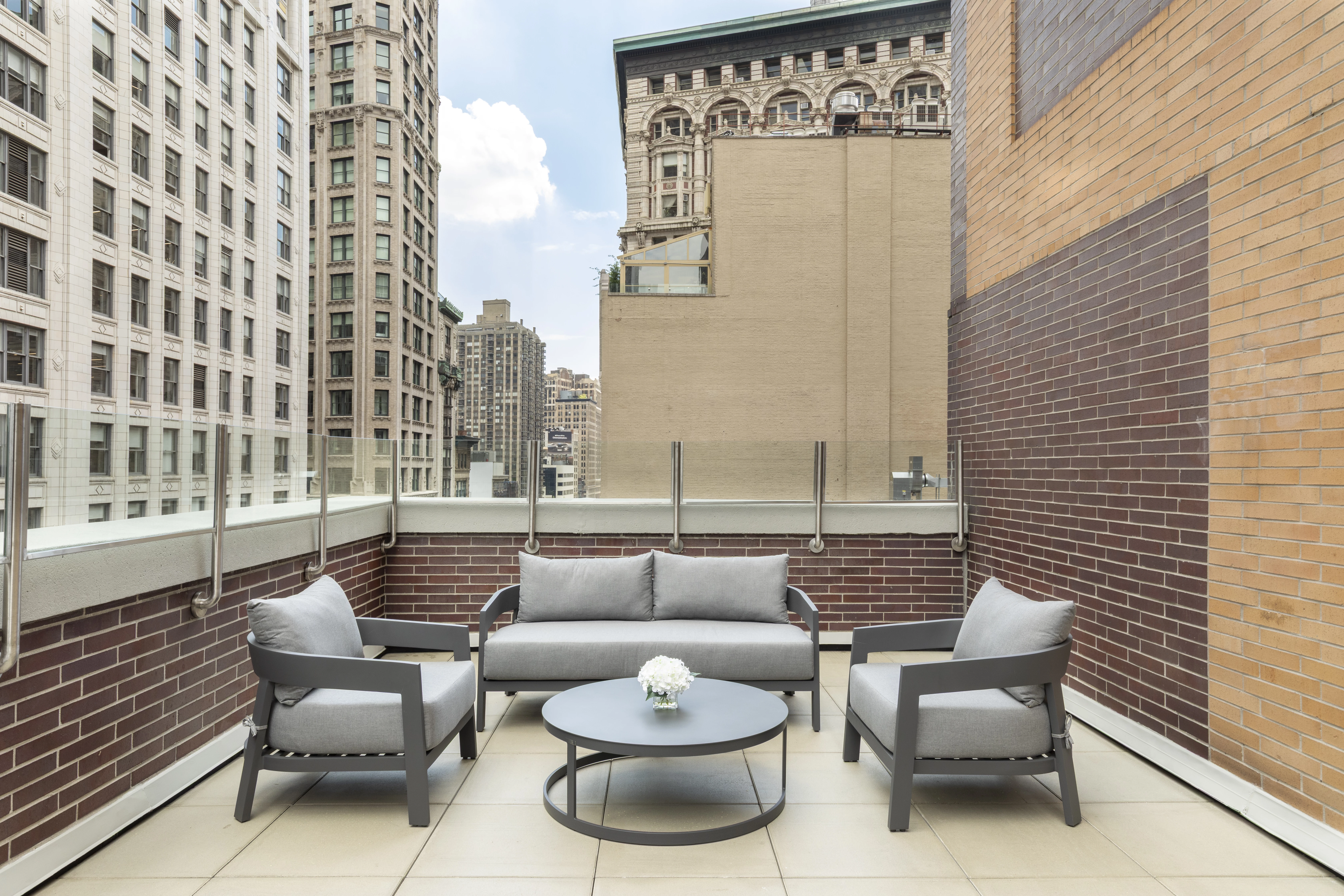 A rooftop seating area with a city view