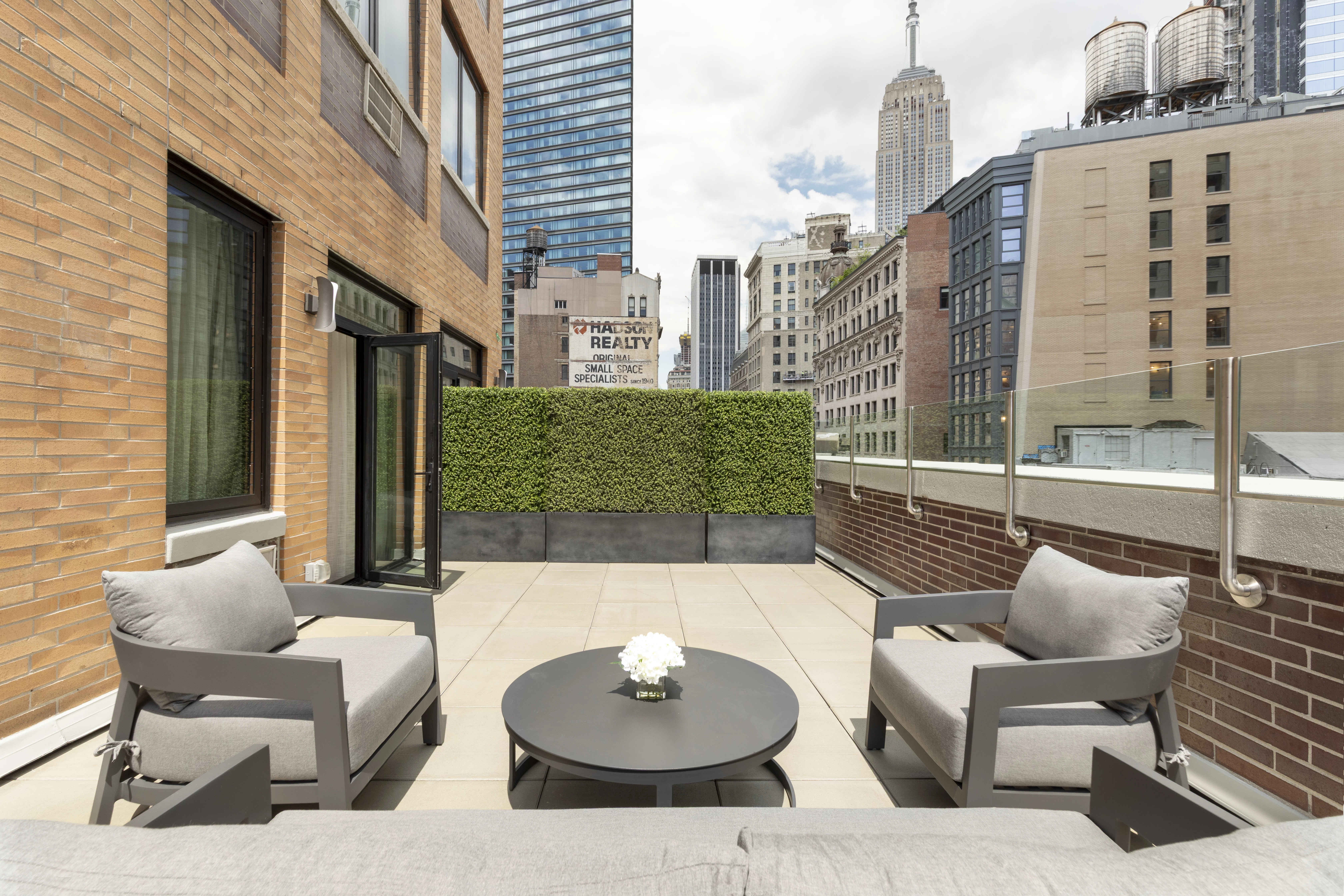 A rooftop patio with outdoor furniture and a city view