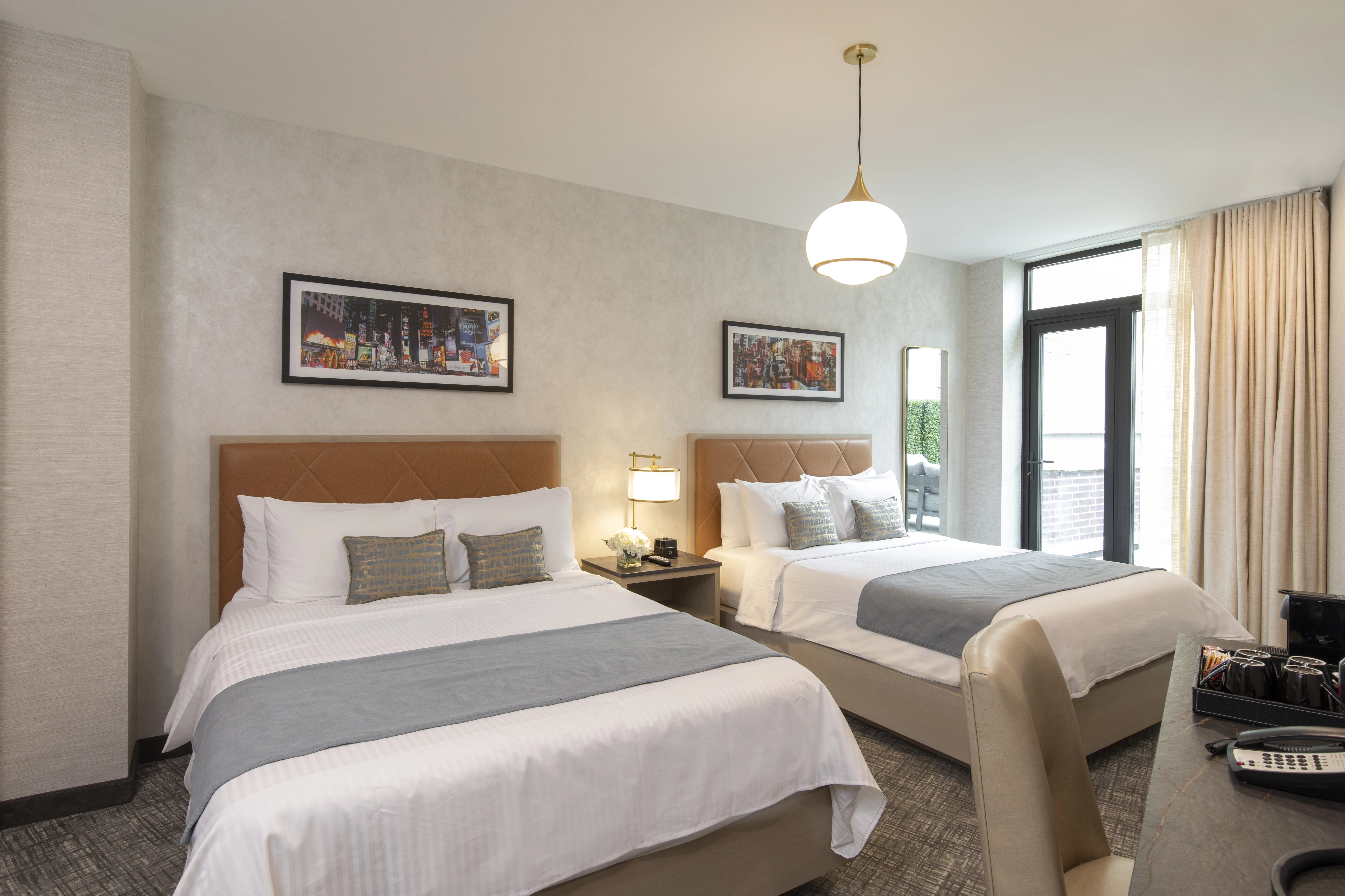 A hotel room with two beds, a desk, and a window