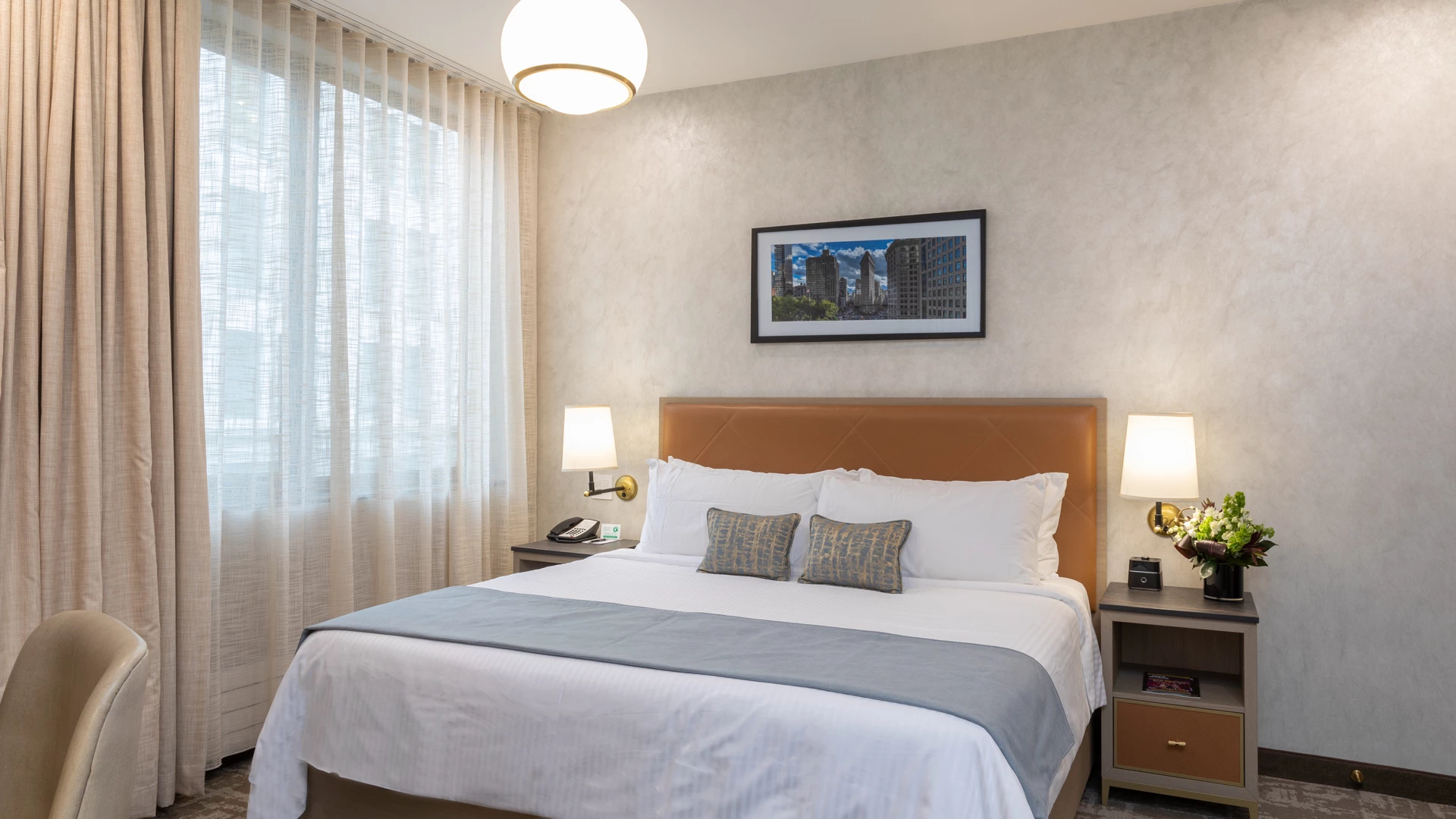 A hotel room with a bed, nightstands, and a window