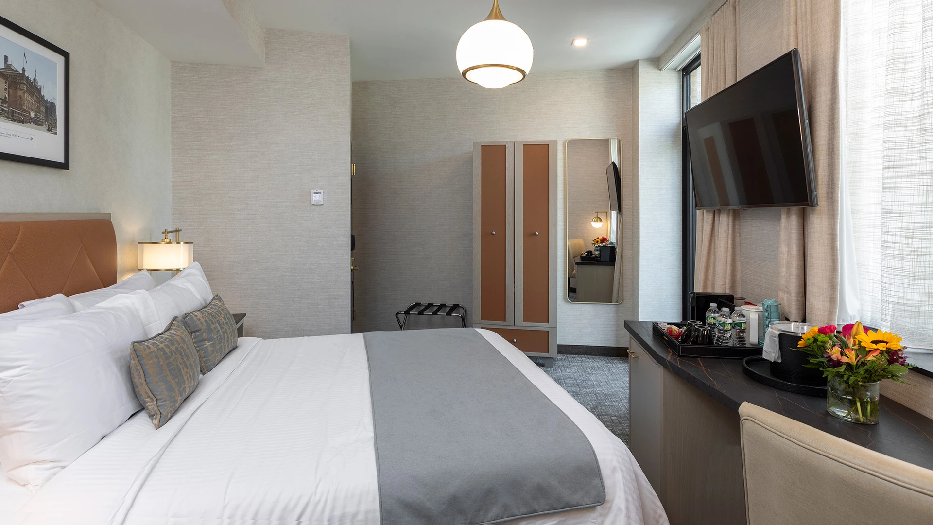 A hotel room with a bed, TV, and amenities.