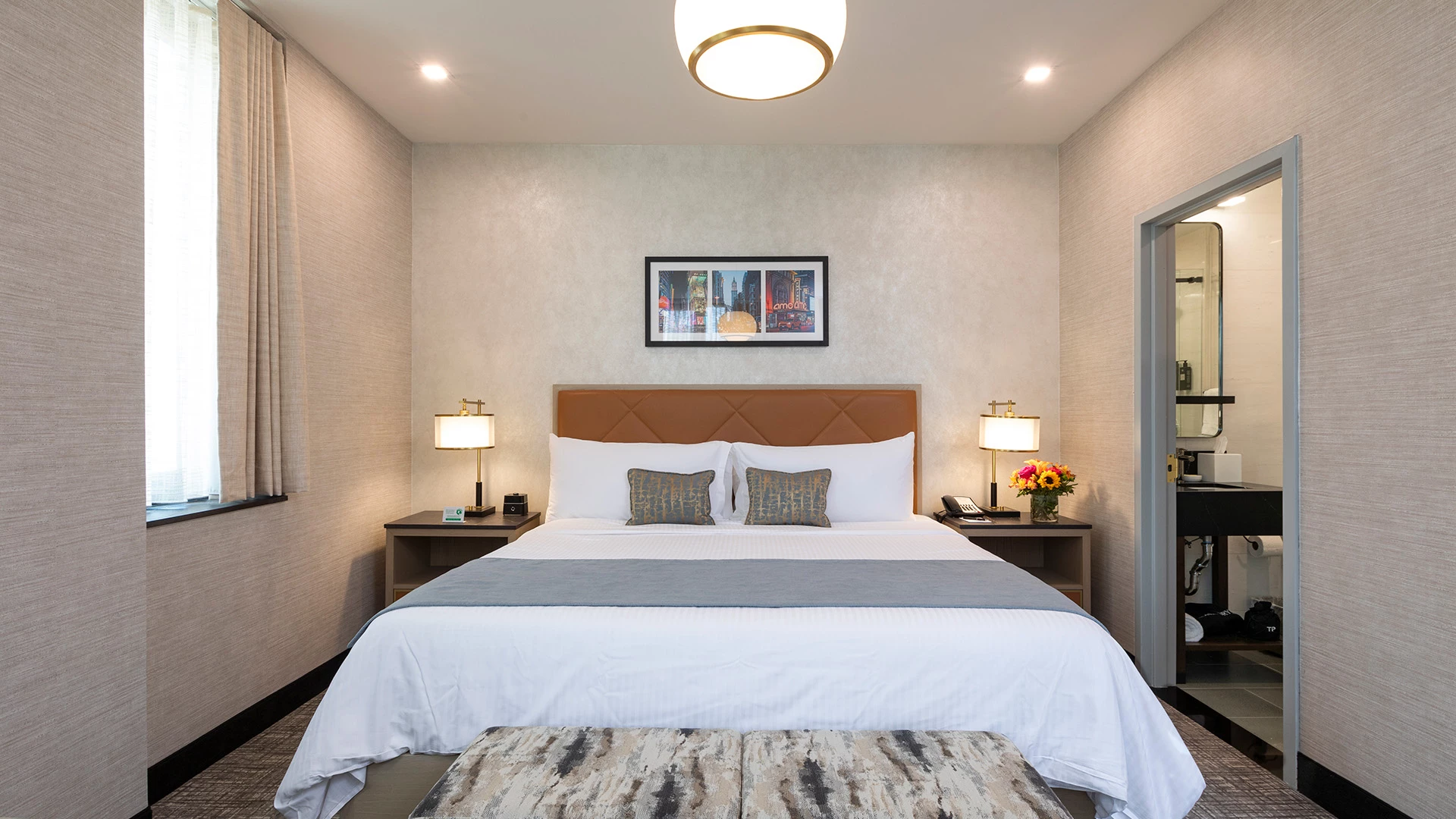 a hotel room with a bed, nightstands, and a bathroom