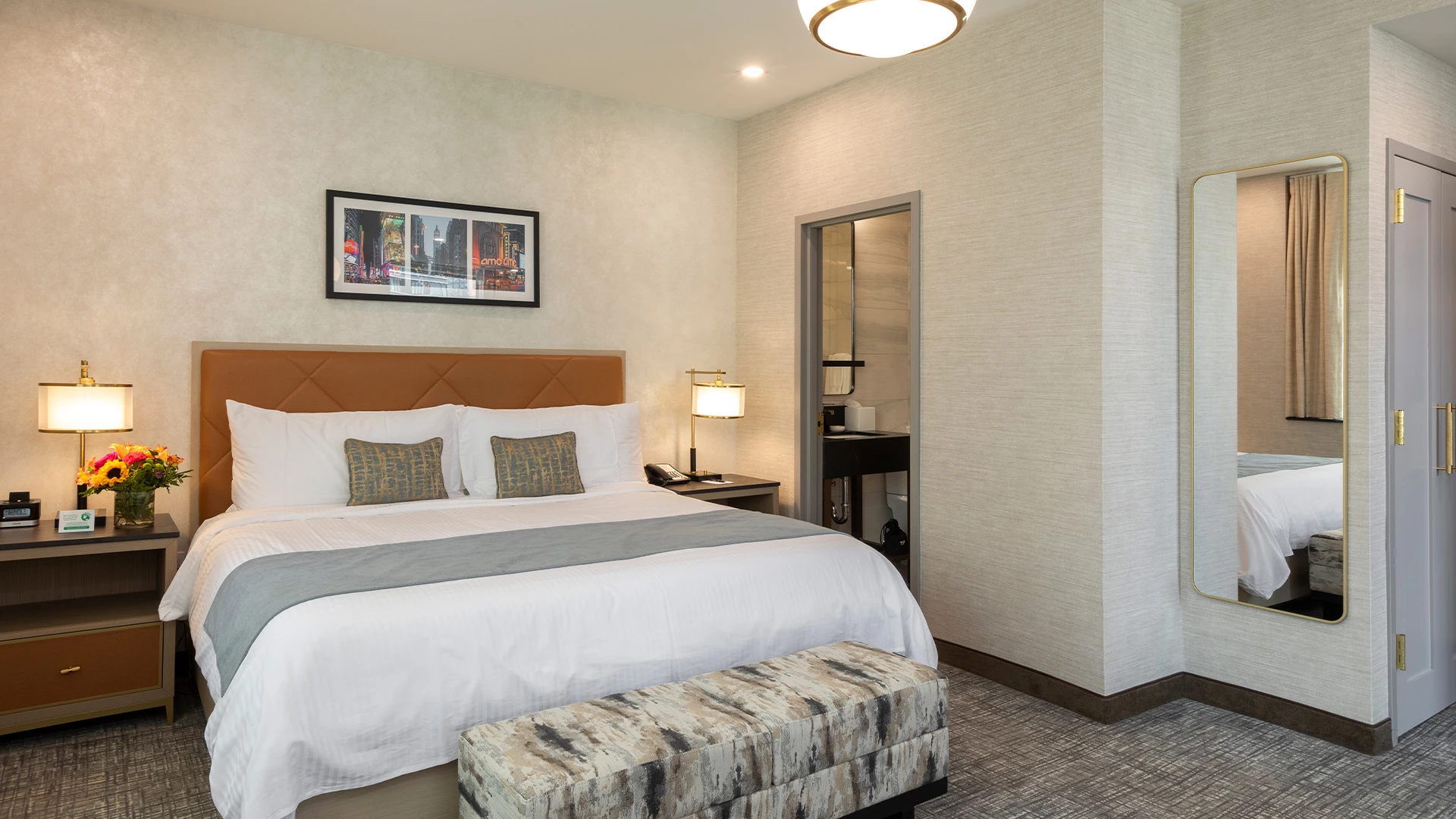 A hotel room with a bed, nightstands, lamps, and a mirror
