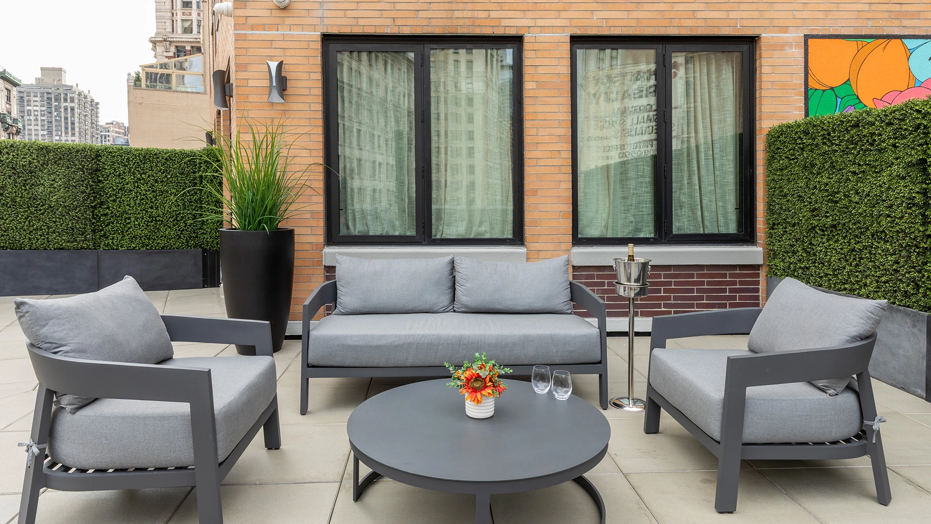 A rooftop patio with outdoor furniture and a city view.