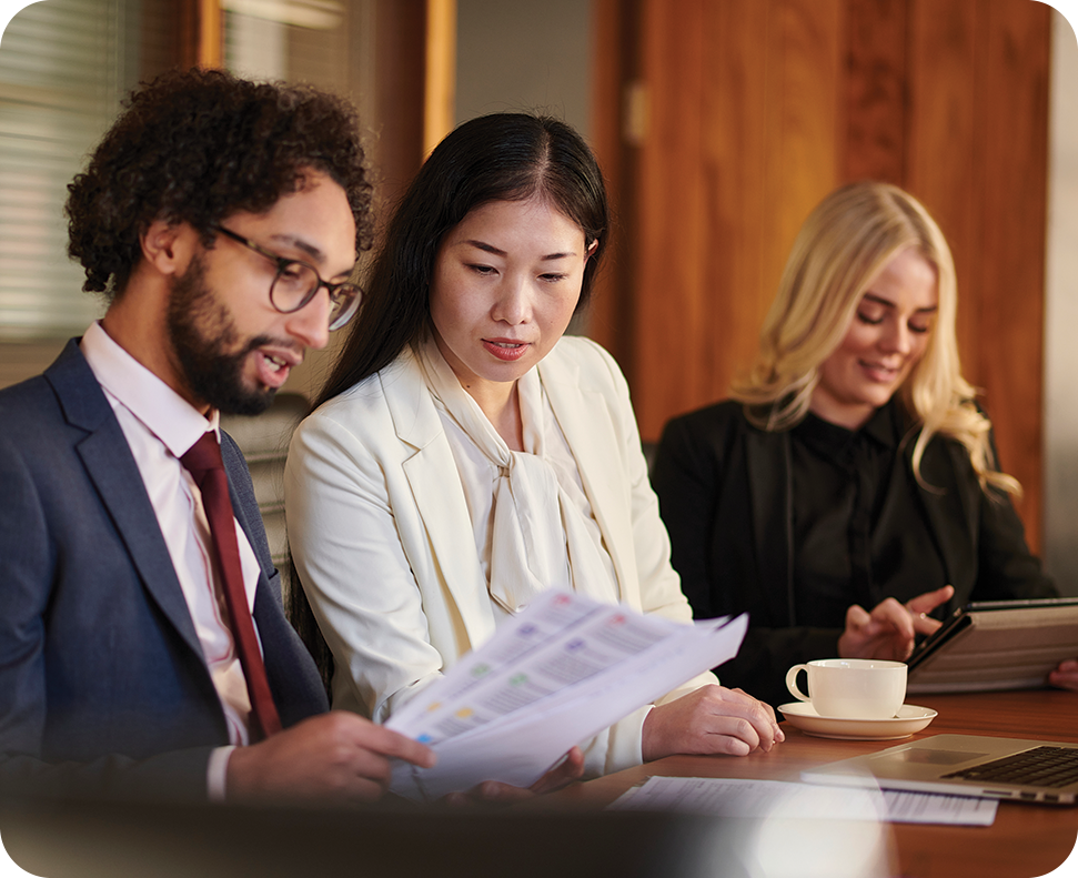 a group of people sitting at a table looking at papers