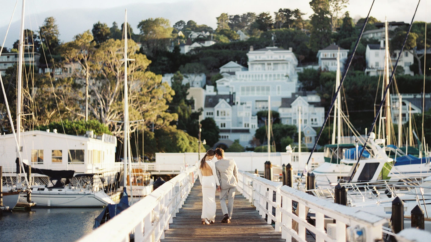 a man and woman walking on a dock