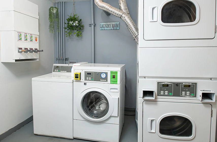 A laundry room with washing machines and dryers.
