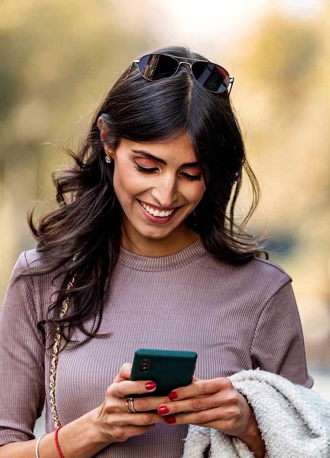 a woman smiling at her phone