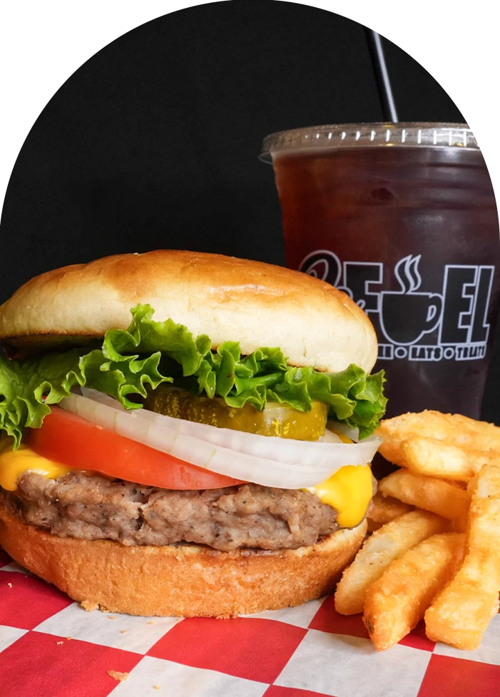 a burger and fries with a drink in the background