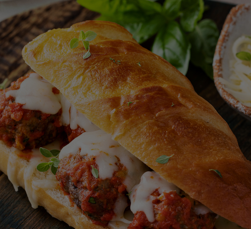 a meatball sandwich with cheese and sauce