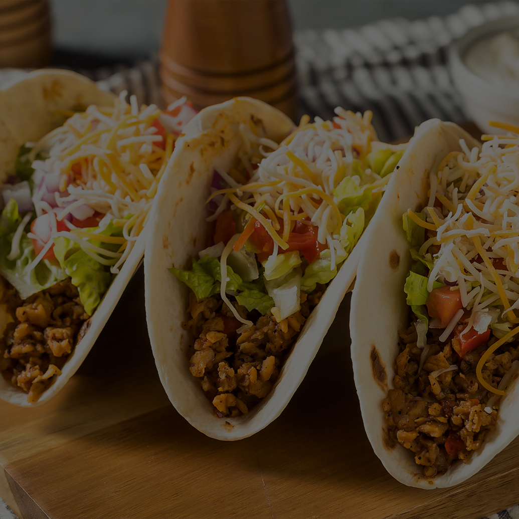a group of tacos on a wooden surface